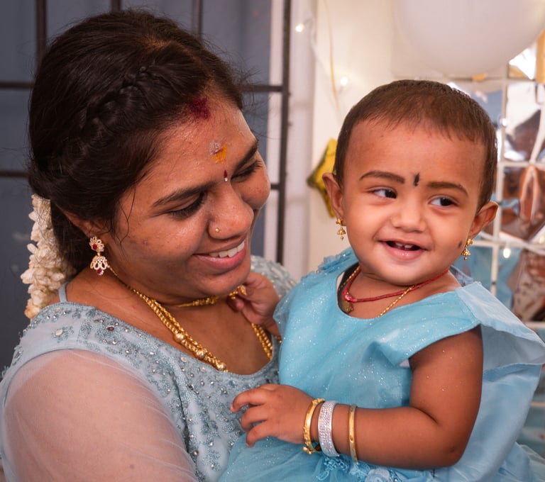 a woman in a blue dress holding a baby