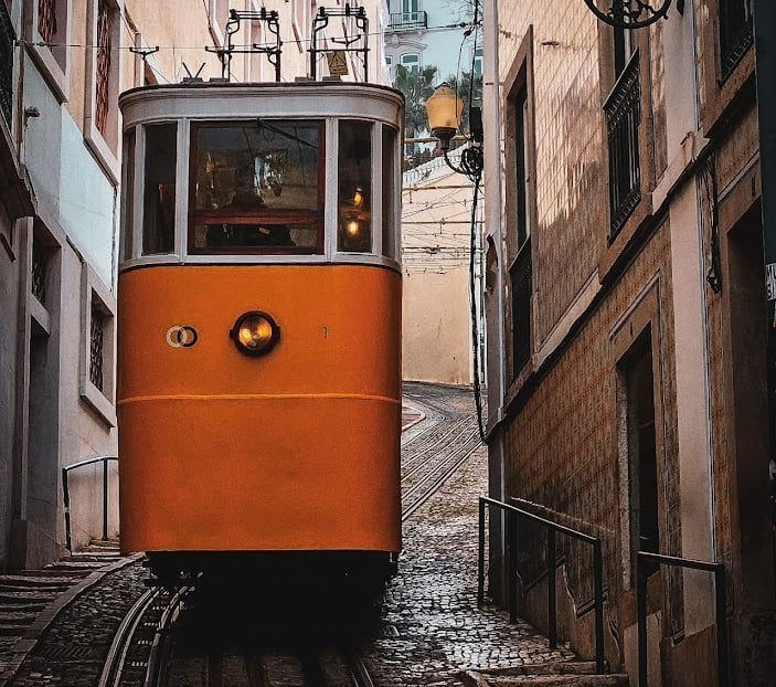 a trolley car on a narrow street in a Lisbon
