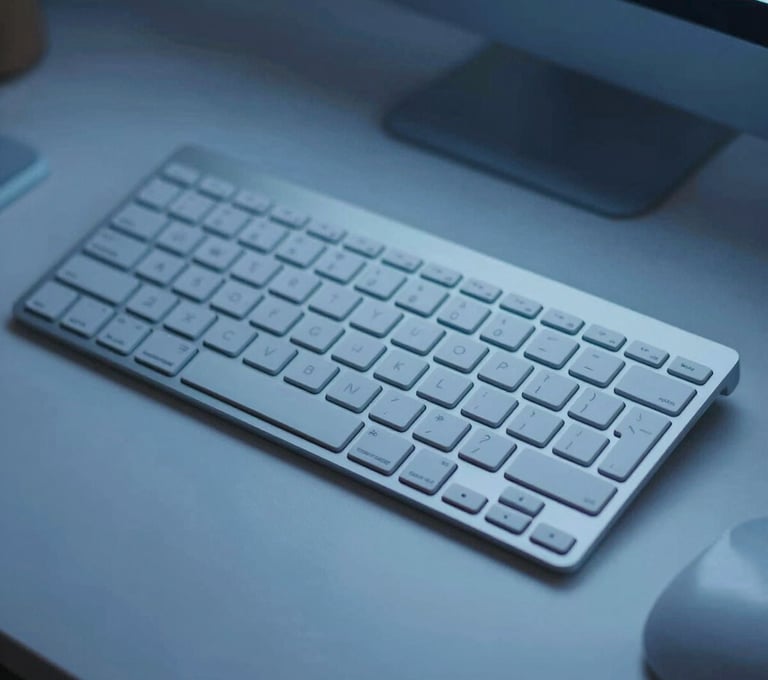 Clean, top-down view of a professional designer's desk with a metallic keyboard, soft blue ambient light, and a minimalist feel.