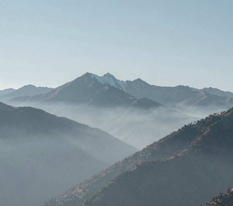 A serene, minimalist landscape of the high-altitude Andes mountains in a Latinoamericano / Español region, captured in muted tones of blue and gray, soft fog rolling between peaks, very clean and artistic composition.