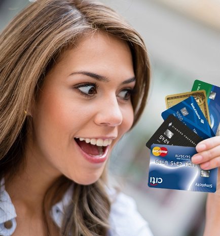 uma jovem mulher segurando vários cartões de créditos