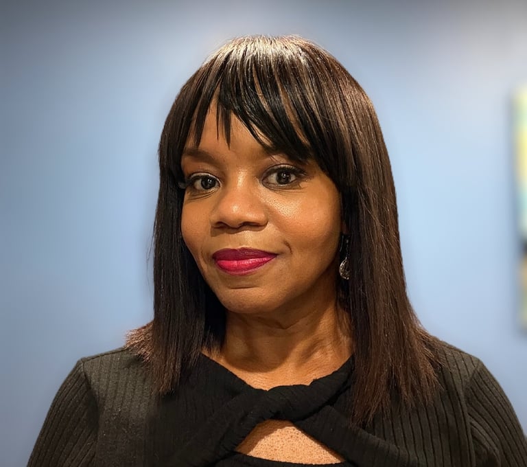 Professional portrait of Robyn smiling with dark hair and bangs wearing a black top.