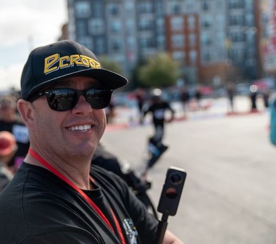 a man in a black hat and sunglasses is holding a cell phone