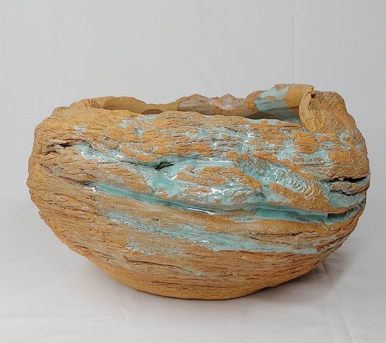 Estelle Del oeuvre artistique d'un pot en grès roux texturé émaillé en vert, inspirée des fa:laises 