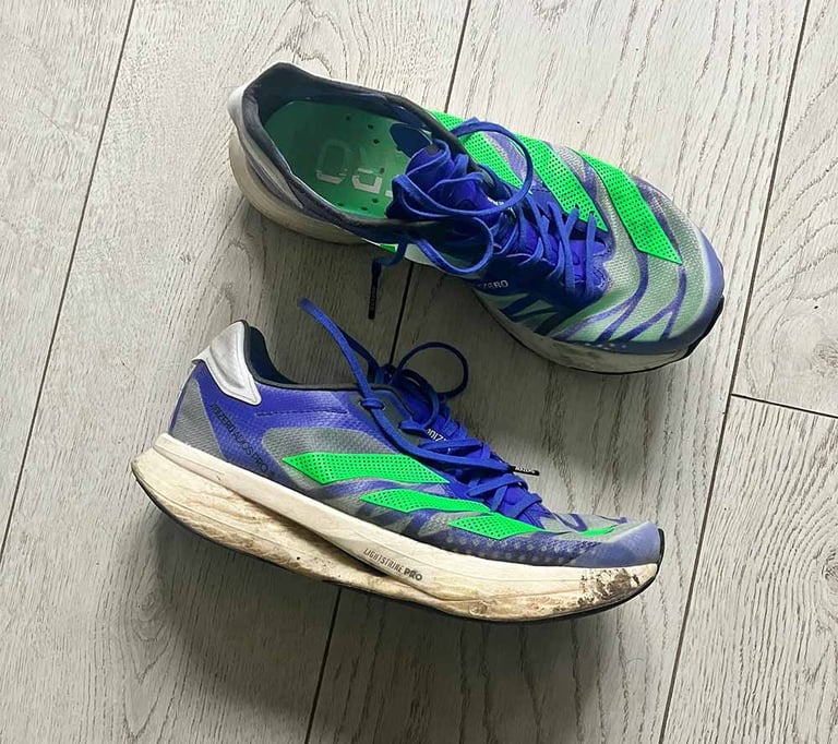 a pair of blue adidas running shoes with green stripes
