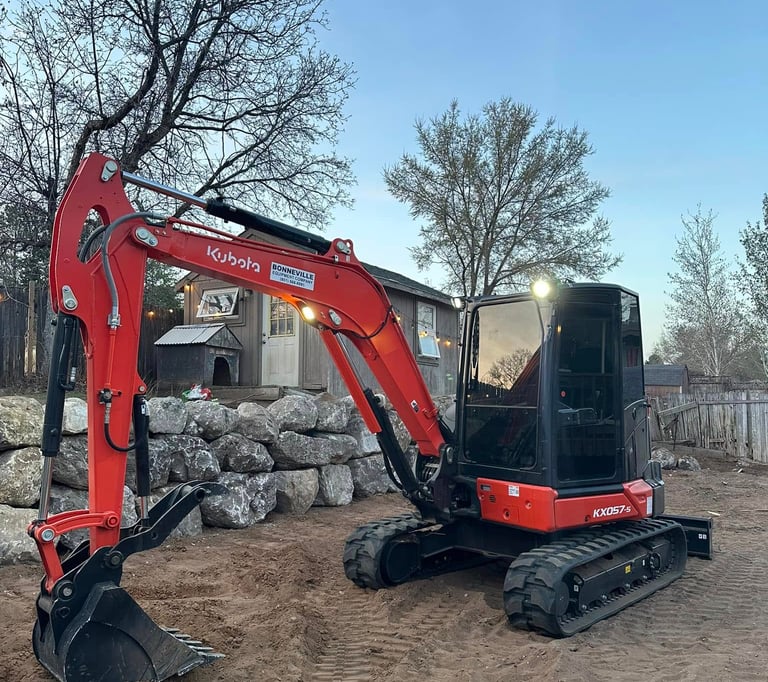 Kubota sitting idle next to completed boulder wall in Ogden, UT