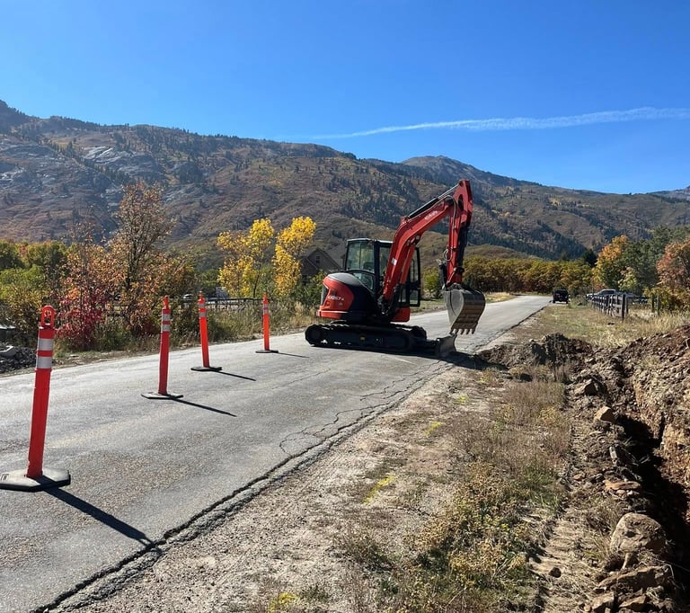 Kubota excavator sitting idle with Utah mountains in background