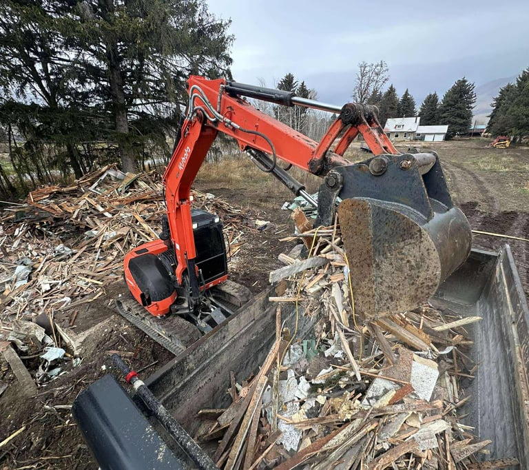 Kubota loading debris from demolition into dump truck