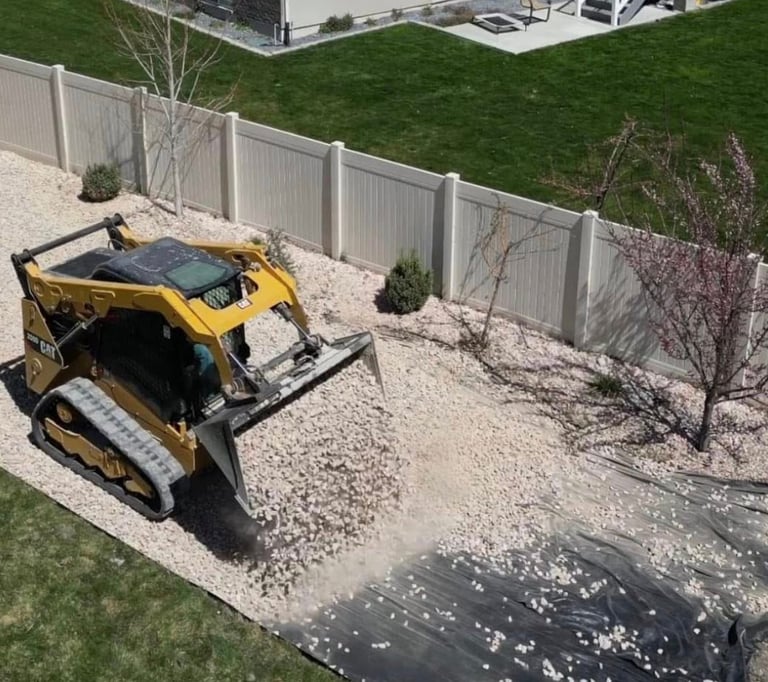 skid steer dumping landscape rock at residential home 