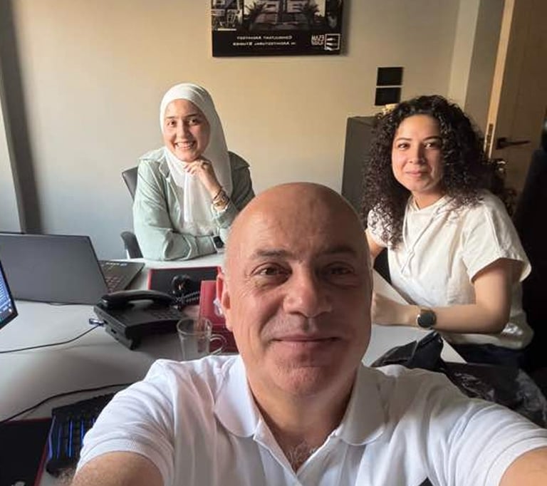 a man and woman sitting at a desk with laptops