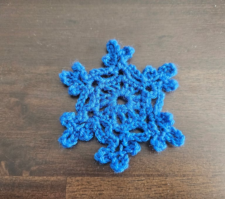 blue crochet snowflake on a wooden table