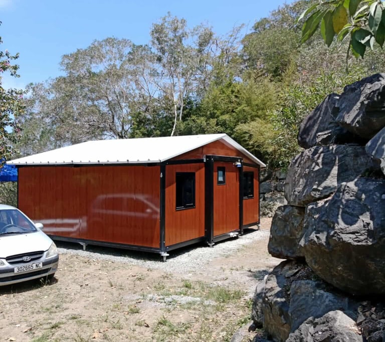 Chalet modulaire avec toit blanc sur un terrain sec et difficile.
