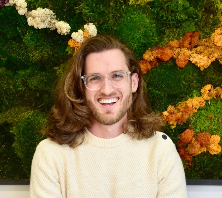 John smiling in front of green wall