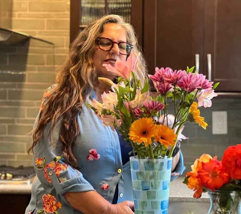 a woman standing in front of a vase with flowers