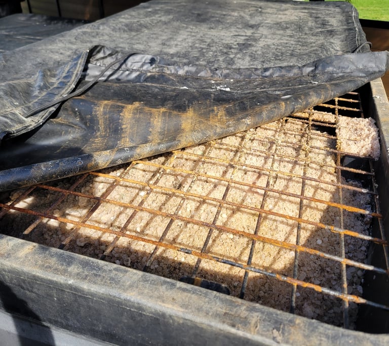 a top picture of a salt hopper filled with salt with a metal grate