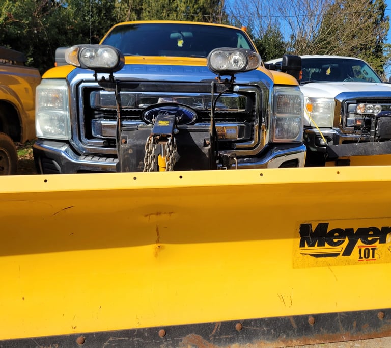 the front of a yellow truck with a yellow meyer plow blade on it