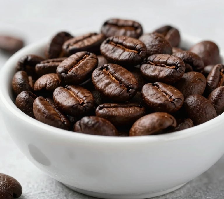 A clean, high-end close-up of dark roasted coffee beans in a white ceramic bowl, set on a minimalist ice grey surface with soft natural lighting.