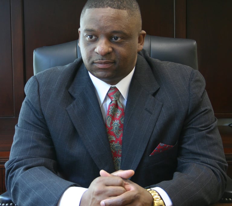 Mark T. Stewart in a suit and tie sitting at a desk