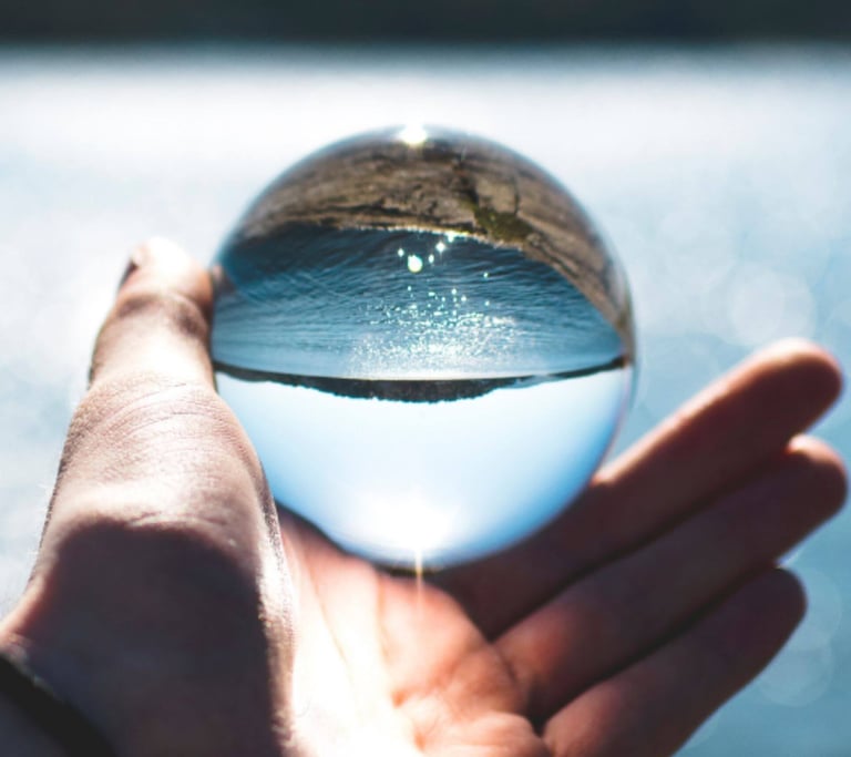 Hand hält eine Glaskugel mit Wasserblick – Symbol für Klarheit und neue Perspektiven durch Hypnose.