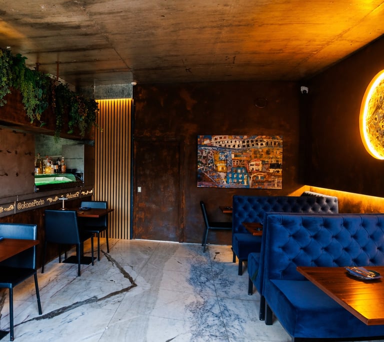 Interior do Okone Sushi Nikkei no Porto com sofás azuis, balcão de madeira, iluminação suave e decoração com plantas