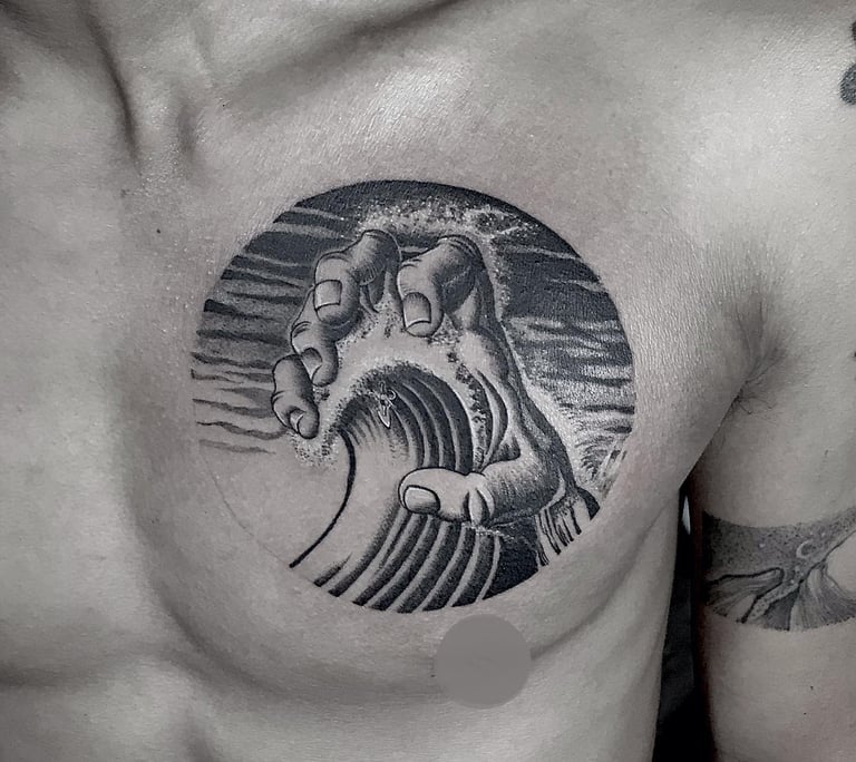 Blackwork tattoo of a hand holding a wave on the chest