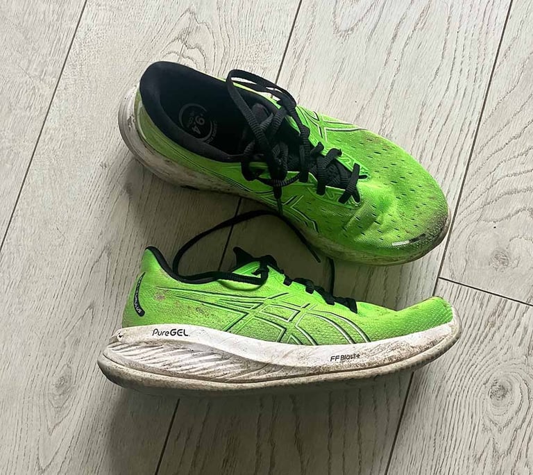 a pair of green Asics running shoes with black laces