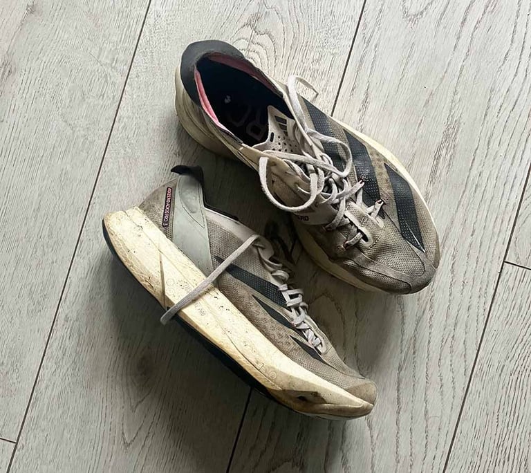 a pair of white adidas running shoes with black stripes
