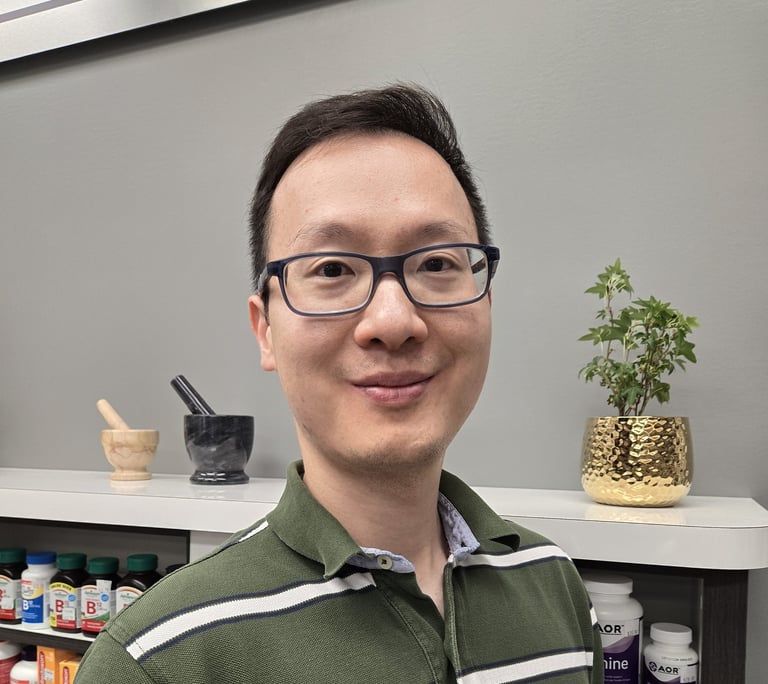 A man with short black hair, glasses and green shirt