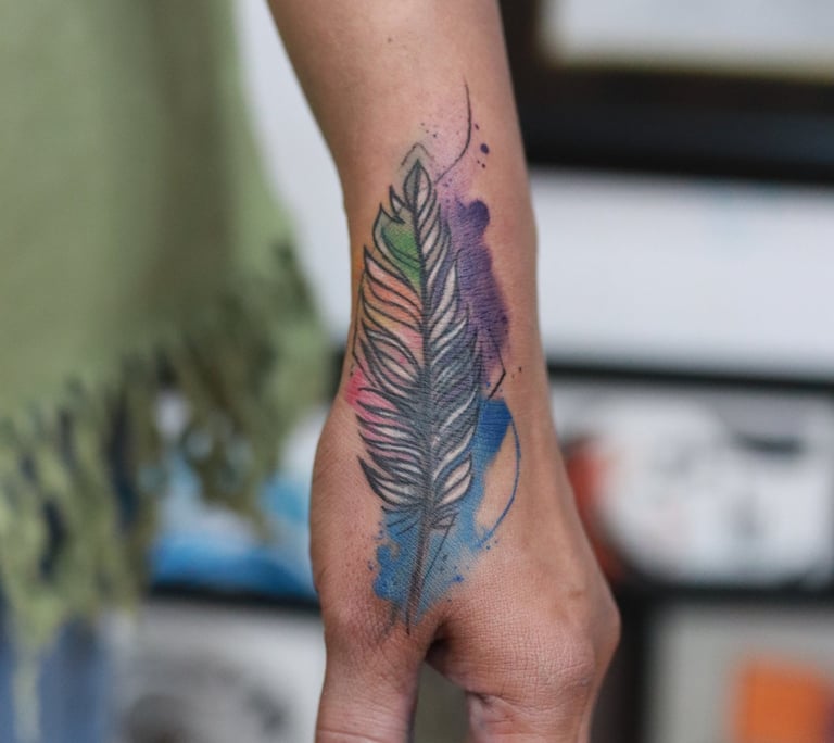 Blue and purple watercolor feather tattoo at Dudo’s Tattoos Hyderabad