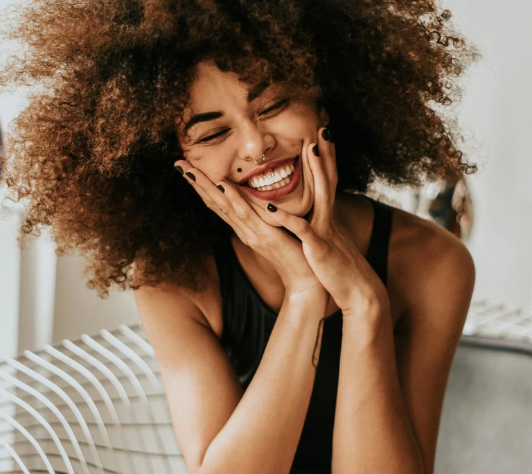 une femme aux cheveux afro bouclés et vêtue d'une robe noire