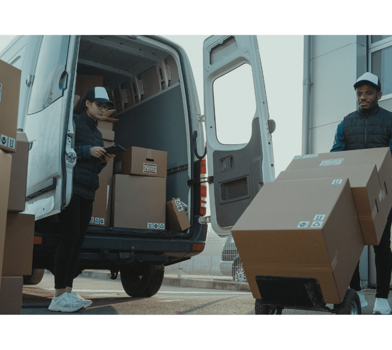 a man and woman moving boxes to a moving house