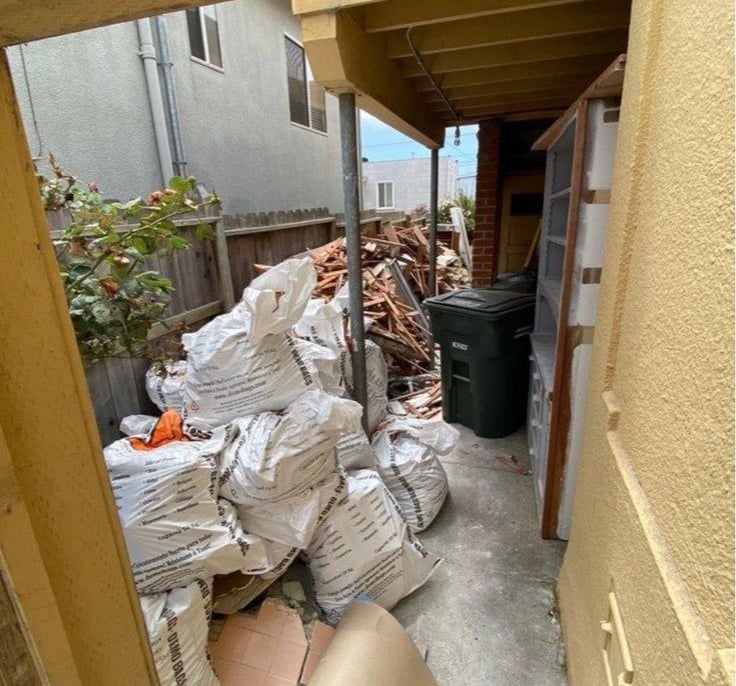 Sacs de gravats et déchets de chantier stockés en attente d’évacuation après démolition intérieure.