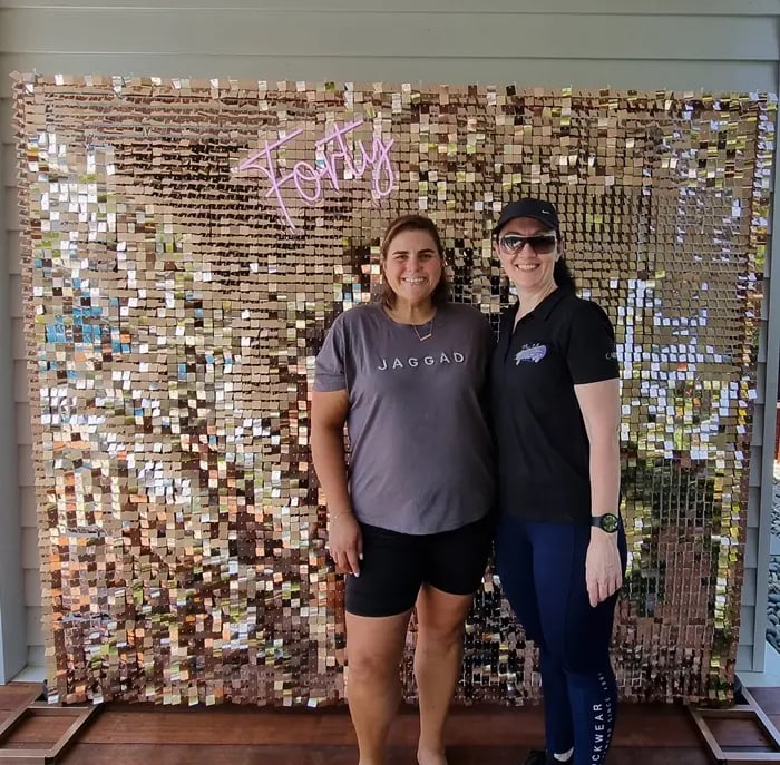 Linell and Carly in front of the rose gold shimmer wall and Forty neon sign in Brisbane.