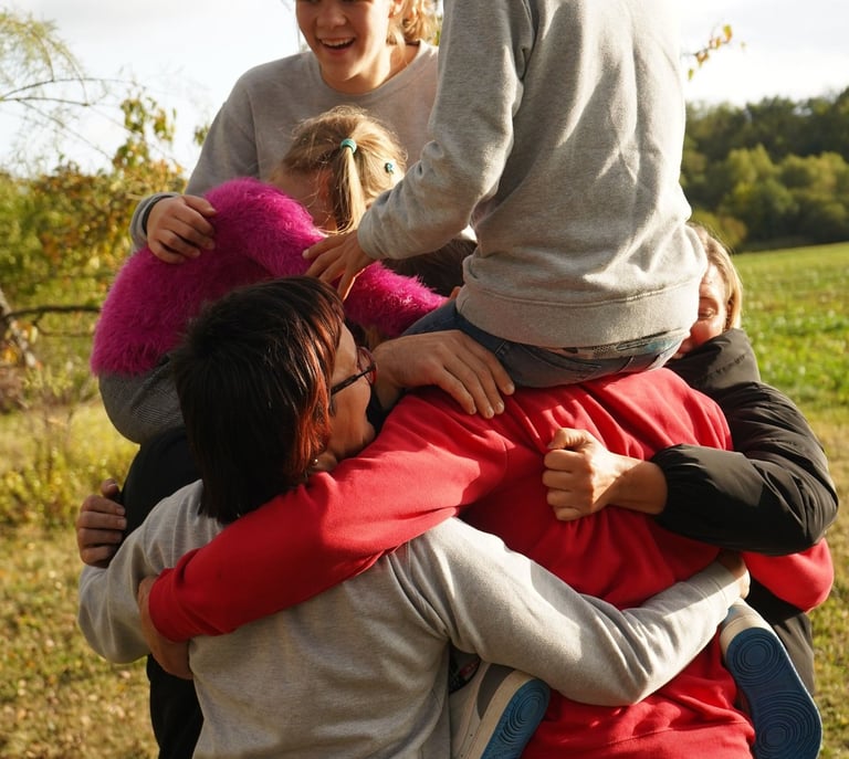 Džiaugsmingi apsikabinimai su bendruomenės nariais