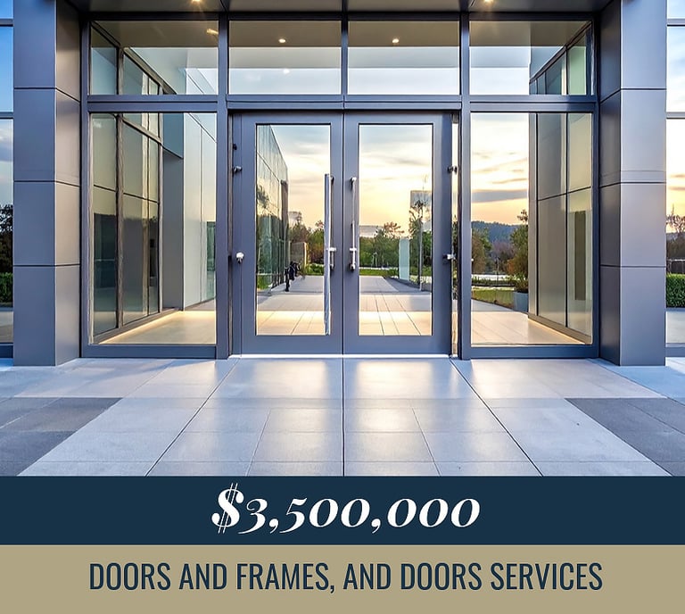 Modern glass storefront entrance with grey aluminum frames and stone tile walkway.