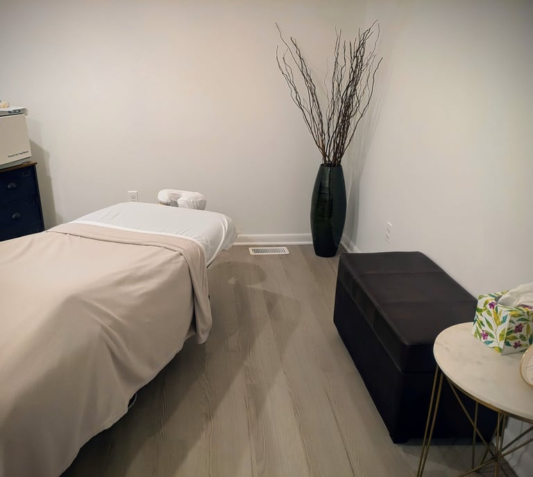 Modern spa therapy room featuring a professional massage table and serene minimalist decor.
