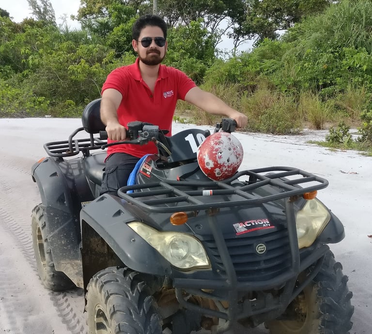 Bhargav sitting on an ATV at a beach in Indonesia