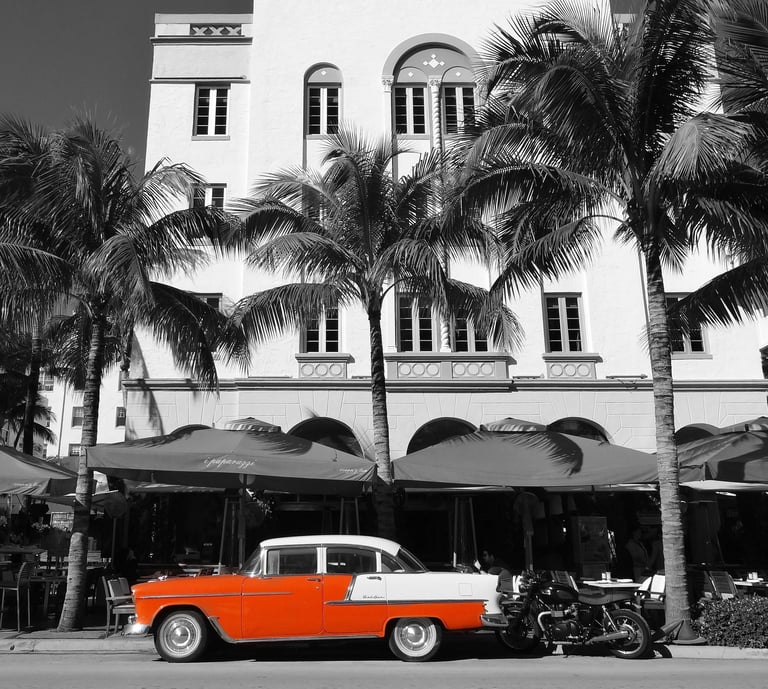 a classic red car parked in front of an art deco building