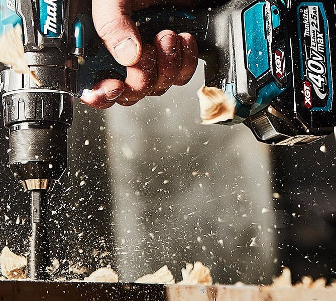 a person using a drillet to drill in a wood