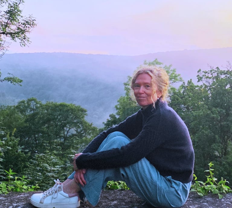 Tanja Holvoet in een rustige natuuromgeving bij zonsondergang.