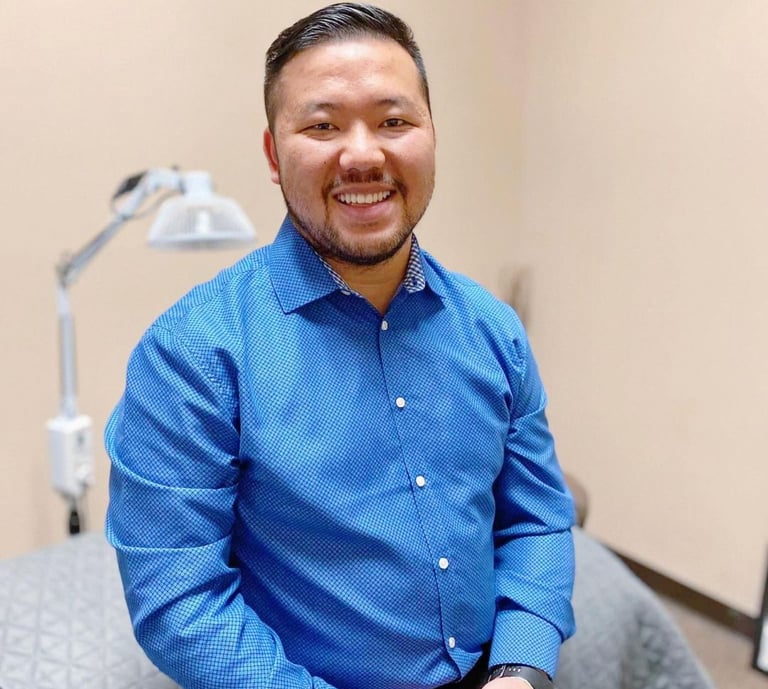 Dr. Xiong in a blue button-down shirt at Balance Naturopathic & Acupuncture Clinic.