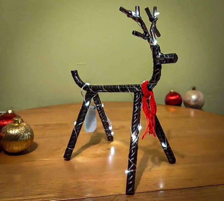 Seasonal designs as represented by a reindeer made from metal rebar, with fairy lights and a scarf