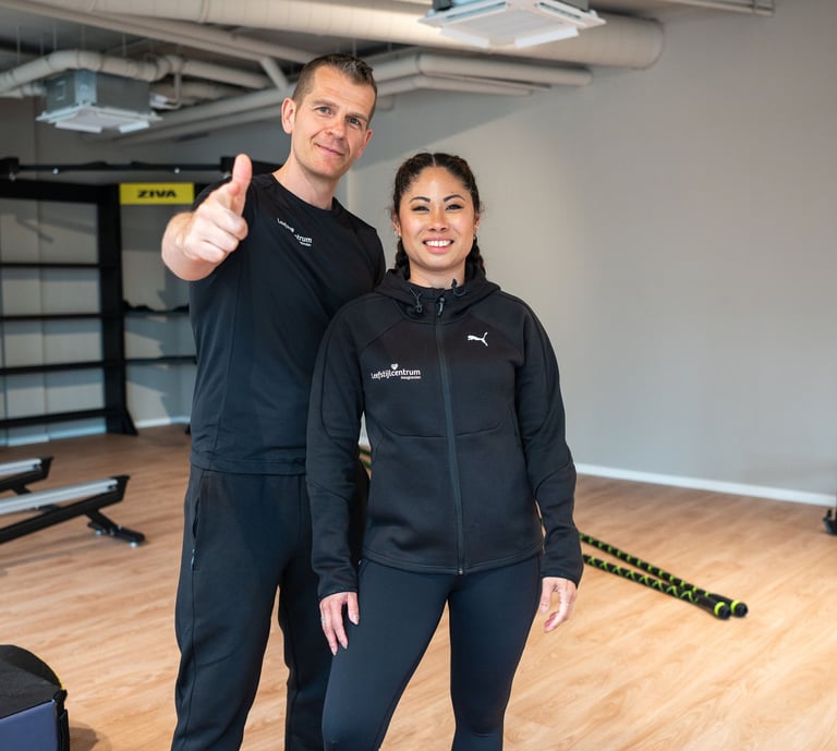 a man and woman standing in a gym