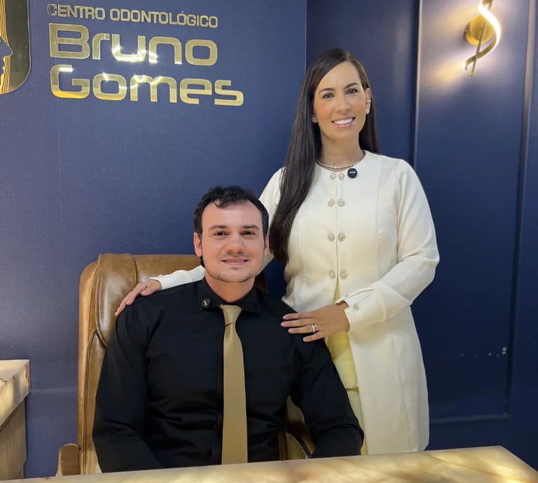 Dr. Bruno Gomes e Dra Bruna. Dentista em Barra do Garças. Sentado no seu consultório.