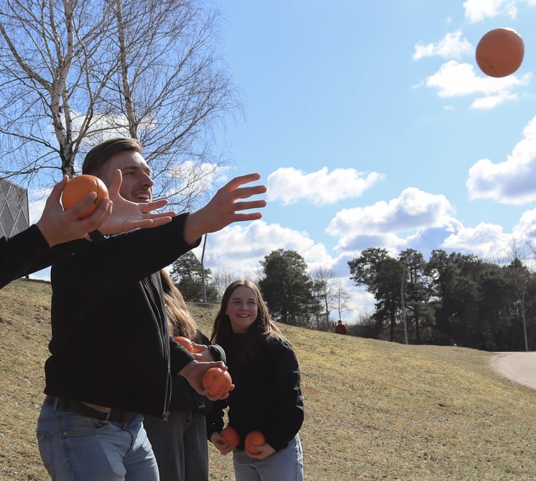 jauni vaikinai gaudo apelsinus