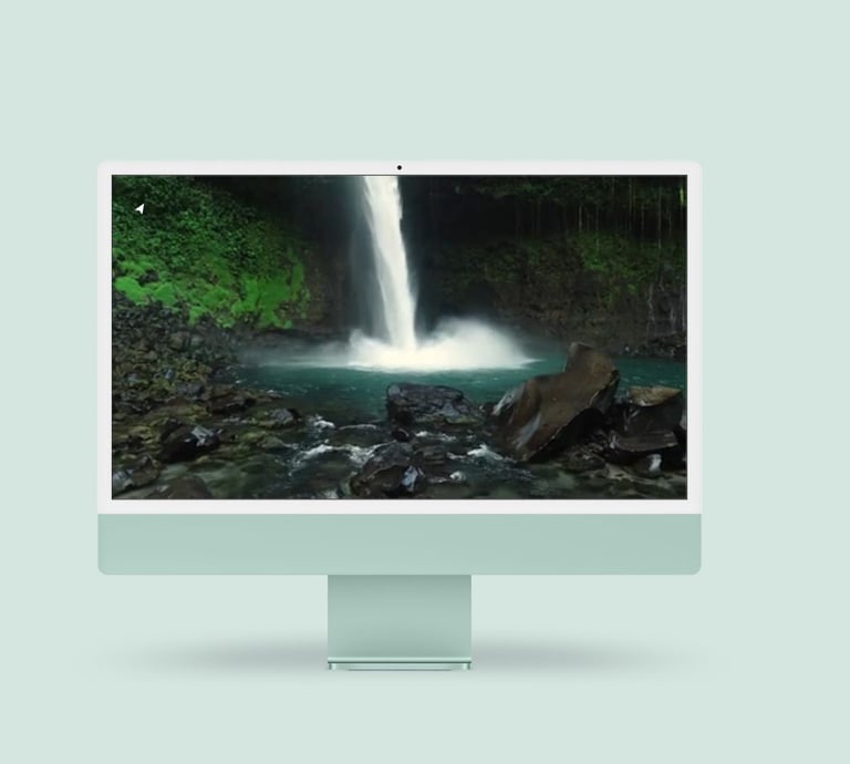 a desktop computer monitor with a waterfall in the background