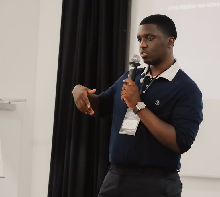 A young Black man giving a presentation with a microphone at a professional seminar.