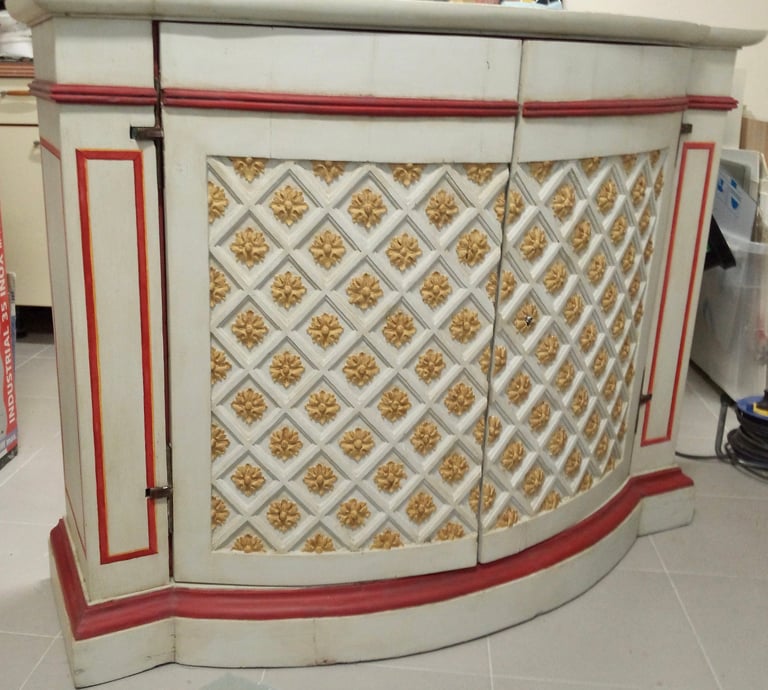 Restauration des peintures d'un buffet d'époque en bois sculpté et peint. Fleurs de lys sculptés.