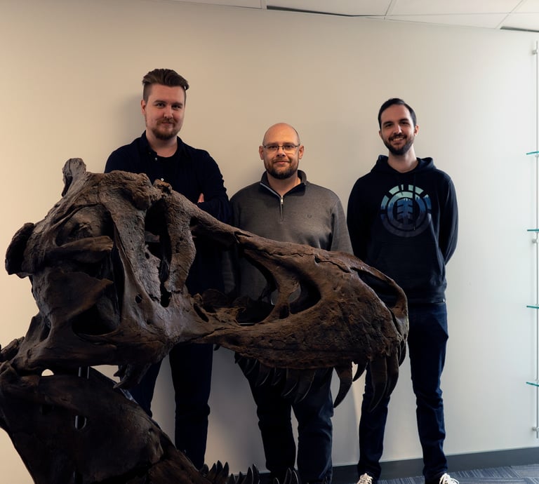 Photo of the team with a full sized replica of a T-Rex skull