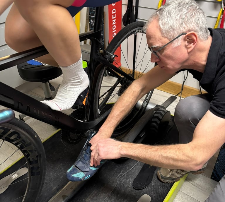 Close-up of a rider having their shoes adjusted by a bike fitter